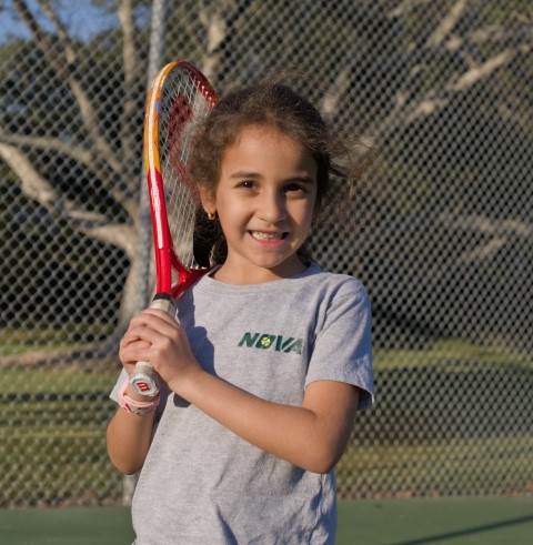 Girl holding a red racket over her shoulder